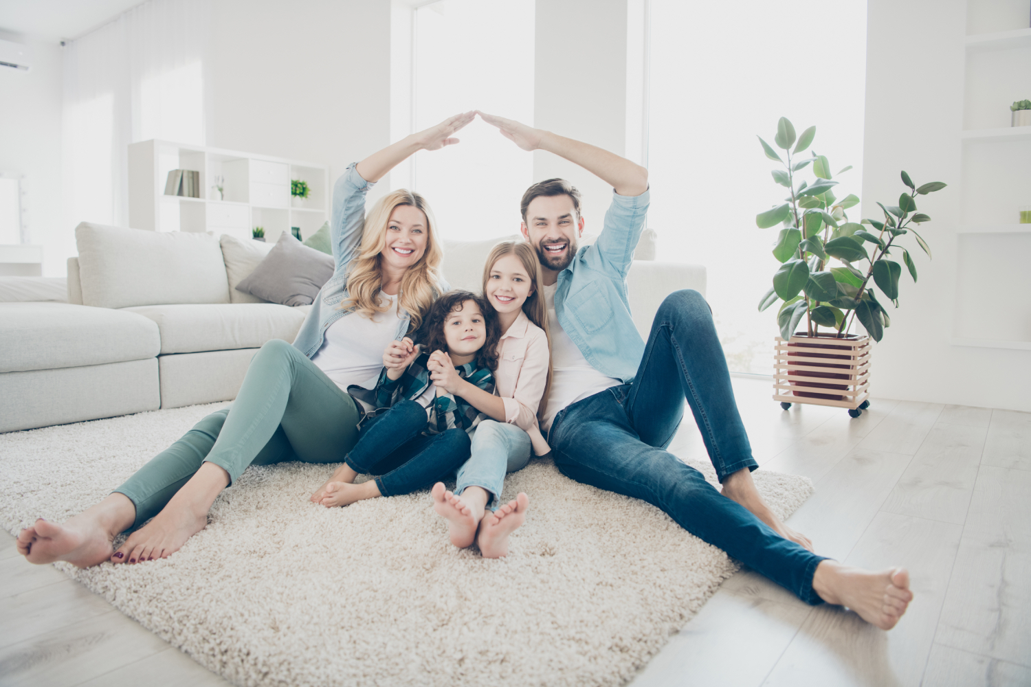 Happy Sydney family of four sitting together in their bright new home secured with a bridging loan
